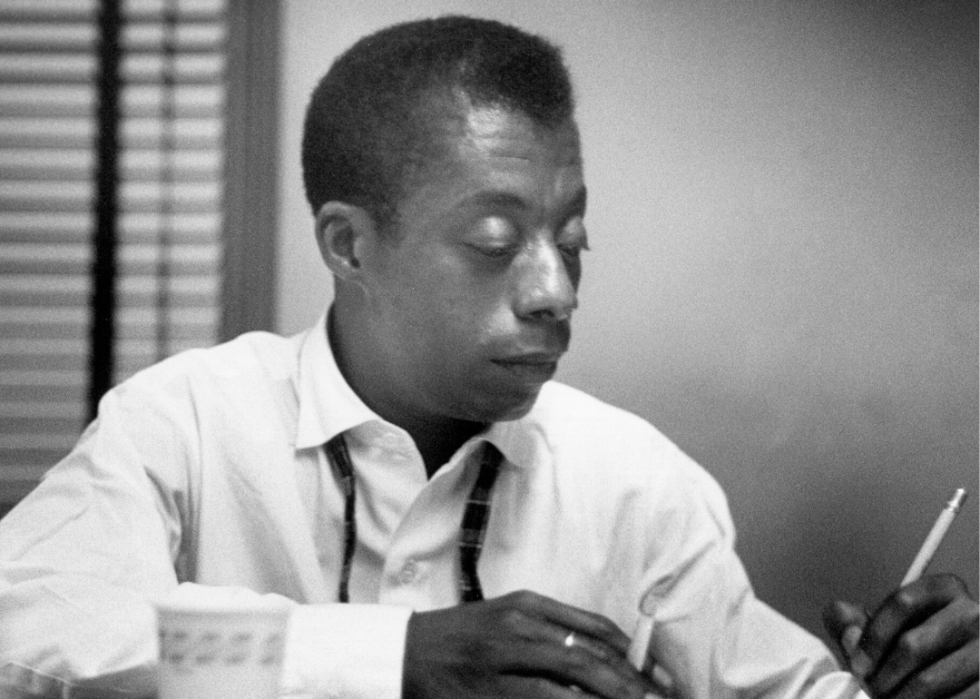 Portretul lui James Baldwin scriind la birou.