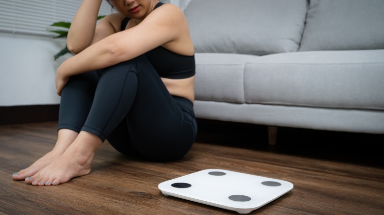 Femeie care se uita cu tristete la scara